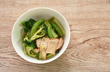 stir fried broccoli with green pea in oyster sauce topping slice grilled pork on bowl