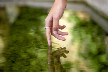 A hand touching the water.