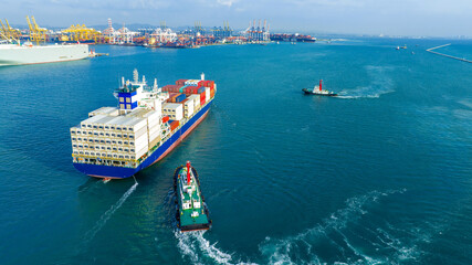 Tub Boat with Stern of cargo ship carrying container and running for import goods from cargo yard port to custom ocean concept technology transportation , customs clearance.