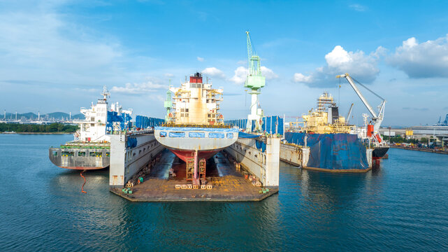 cargo container ship at dry dock concept maintenance service working in the sea. Insurance and Maintenance Cargo Ship concept. Freight Forwarding Service maintenance Insurance