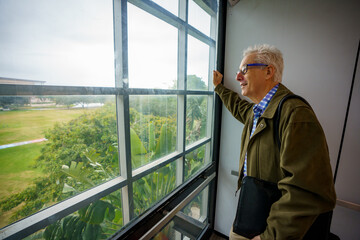 PHoto of a college professor looking out of an elevator window view © Felix Mizioznikov