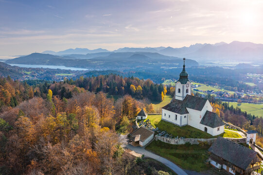 Sternberg church and idyllic graveyard in Wernberg, Carinthia, Austria during autumn with a view to Lake Wörthersee in the background.