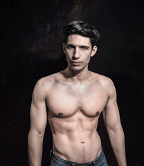 Shirtless attractive young man looking at camera in studio