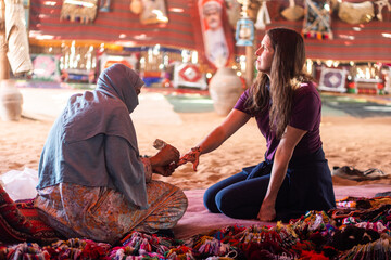 Woman getting henna at a bedouin tent - obrazy, fototapety, plakaty