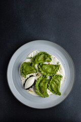 delicious Ukrainian dumplings with sauce on a plate.
