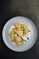 delicious Ukrainian dumplings with sauce on a plate.
