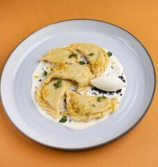 delicious Ukrainian dumplings with sauce on a plate.
