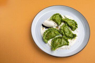 delicious Ukrainian dumplings with sauce on a plate.
