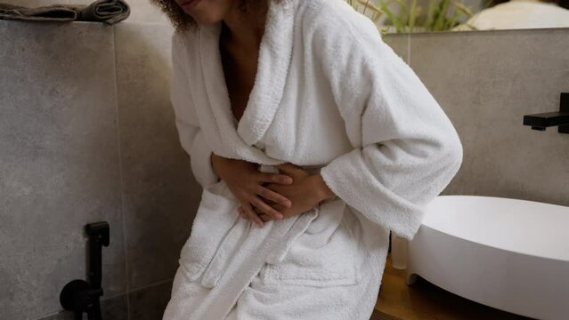 Closeup of African American woman having stomachache, painful period, cramps