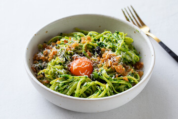 Linguine pasta with black garlic, spinach sauce and egg yolk