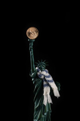 Statue of Liberty with a neck tied with a warm scarf and a coin in denomination of 1 American dollar instead of a torch