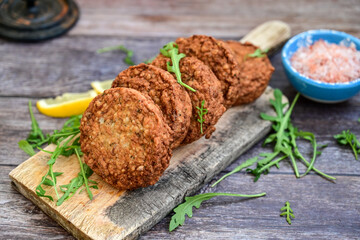 Home made  pork meatballs with  fresh cherry tomatoes on wooden rustic background. Deep fried minced  meat patties on cutting board.