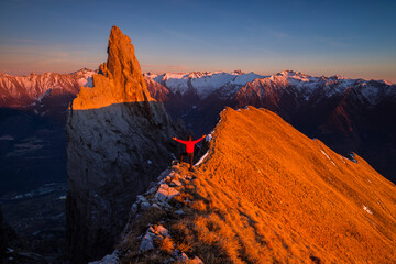 Hiker on sharp mountain ridge during sunset, Italian alps, Valle Camonica, Lombardy, Italy