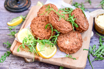 Home made  pork meatballs with  fresh cherry tomatoes on wooden rustic background. Deep fried minced  meat patties on cutting board.