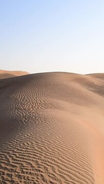 Walking in the sand dunes in the desert, desert landscape in vertical video
