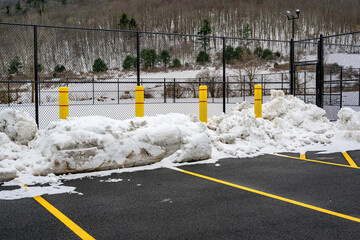 4 Large Yellow Concrete Pillars are placed on the edge of the parking lot to protect the Tennis Court fences from being damaged during snow plowing in the winter in Upstate NY. © Chet Wiker
