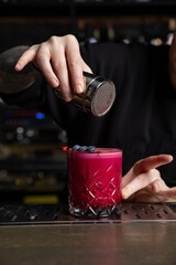 the bartender prepares a delicious alcoholic cocktail	