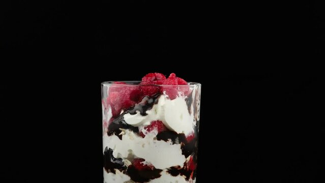 Dessert in glass with cream, berries and liquid chocolate.