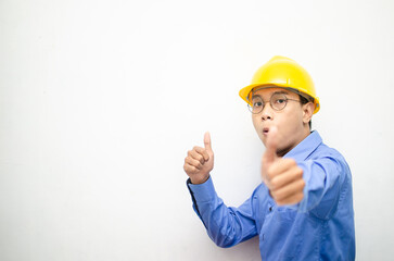 asian construction worker wearing yellow safety helmet and smiling and pointing finger with happy and shocked expression. billboard model advertisment concept. construction worker presenting something