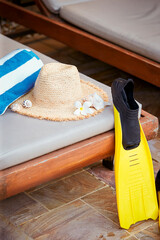 Fototapeta na wymiar Wooden beach chair, flippers and summer hat 