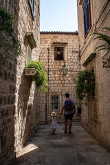 Fototapeta na wymiar Father and little daughter walking on narrow streets of Mediterranean town.