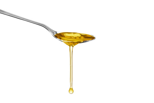Oil honey olive drop dripping from metal spoon isolated on white background. Side view, Copy space.
