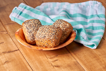 Bun with poppy seeds and sesame on the wooden table.