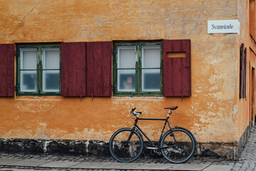 Fototapeta na wymiar bicycle in front of a house with an orange wall in copenhagen, denmark