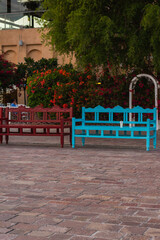 two benches blue and red, at park