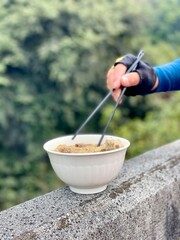hand holding bowl of rice