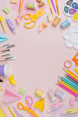 Pink pastel background with various colorful material for creativity and art activity.  Stationery and supplies for drawing and craft with .copy space.  Primary School or kindergarten.