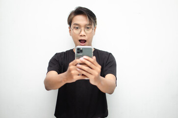 Fototapeta premium Happy shocked asian man in peek a boo hair while holding phone receiving good news.