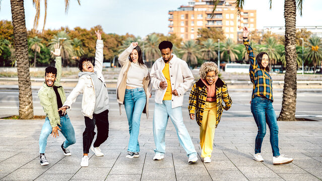 Multicultural Friends Walking At Barcelona Boardwalk On Funny Mood - Genz Guys And Girls Acting Crazy Move By Urban Street On Party Behaviour - Trendy Vacation Life Style Concept - Bright Vivid Filter