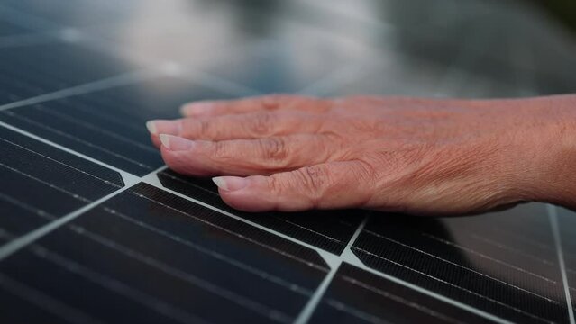 Close up of young engineer hand is checking the operation of sun and cleanliness of photovoltaic solar panels on a sunset. Renewable energy, technology, electricity, service, green, future. footage