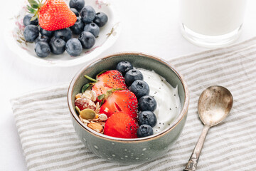 Oat muesli with yogurt and fresh berries in a bowl for a healthy breakfast