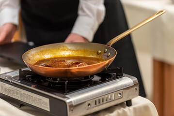 Poire et caramel préparés dans une poêle dans la cuisine d'un restaurant