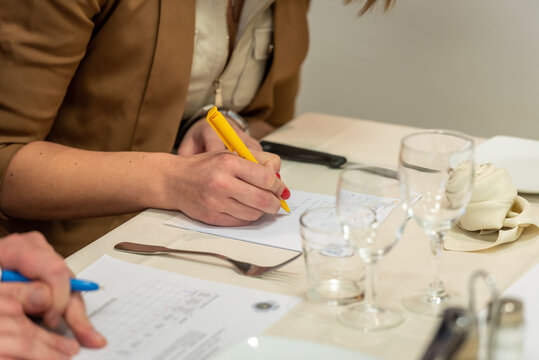 Notation d'un concours culinaire, gros plan main et feuille de notation