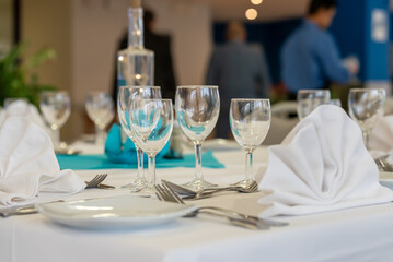Table de restaurant mise en place, verres, assiettes et couverts
