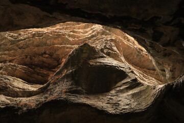 Bizarre shapes in a dark mountain gorge - with layers illuminated by the sun.