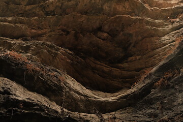 Bizarre shapes in a dark mountain gorge - with layers illuminated by the sun.