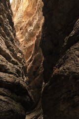 Bizarre shapes in a dark mountain gorge - with layers illuminated by the sun.