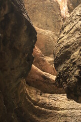 Bizarre shapes in a dark mountain gorge - with layers illuminated by the sun.