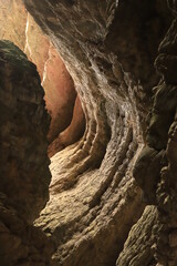 Bizarre shapes in a dark mountain gorge - with layers illuminated by the sun.