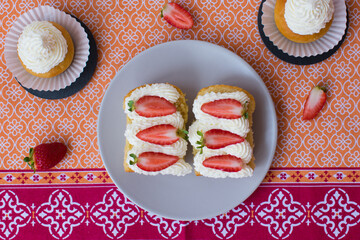 Pastel empapado en almíbar con nata montada y fresas naturales, babá al ron