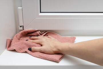 woman wipes the threshold at the door with a rag
