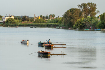 Pescadores con barcas por el rio