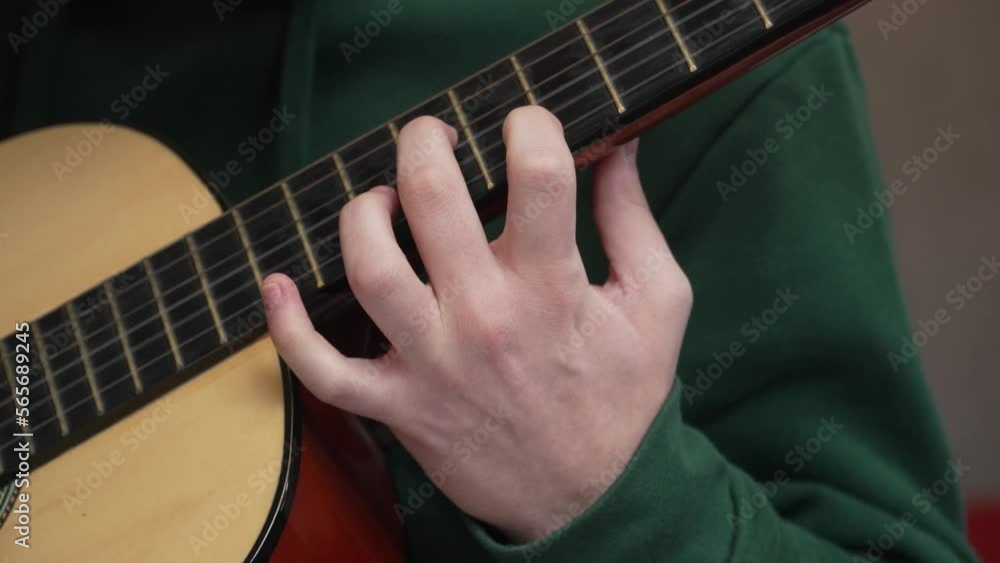 Wall mural close up on hand of unknown caucasian man hold and play guitar