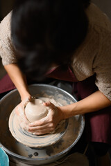Closeup of potter's hands making clay water pot on pottery wheel. Clay pots are used since ancient times and can be found in Indian subcontinent.