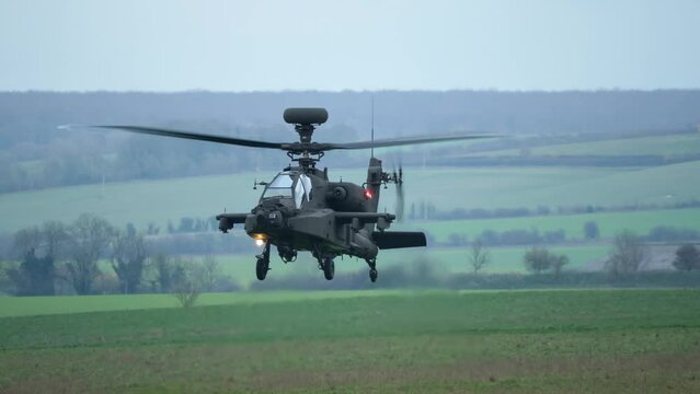 close-up front view of British army AH-64E Boeing Apache Attack helicopter gunship ZM722 ArmyAir606, AH64E in a low hover on a military exercise, Wilts UK