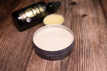 Men's beard balm, oil, wax on wooden background.